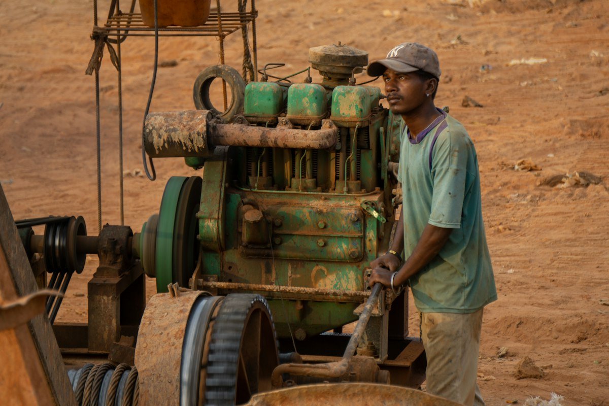 Opérateur à côté d’un moteur diesel sur un site minier en terre rouge